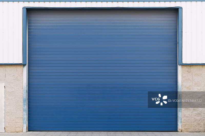 车库的蓝色门正对着建筑物的外面，街上没有人图片素材