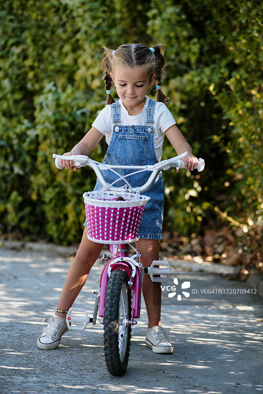 一个女孩骑着她的粉色自行车的画像图片素材
