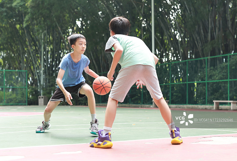一个亚洲男孩在户外打篮球图片素材