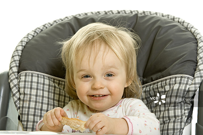 女婴吃早餐时被隔离在白色图片素材
