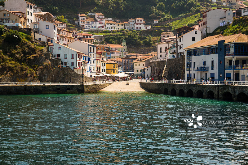 西班牙北部阿斯图里亚斯，阳光明媚的夏日，在海边欣赏色彩缤纷的库迪列罗小镇的港口图片素材