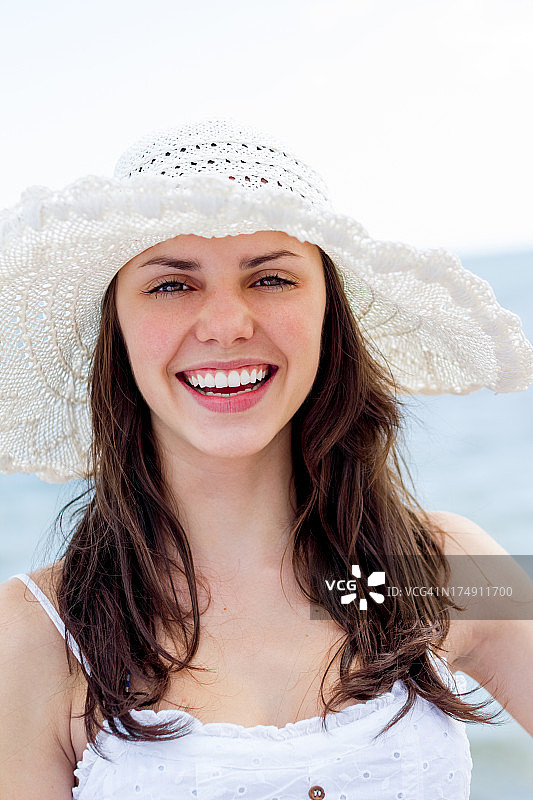 年轻女子在白色的夏装和针织太阳帽图片素材