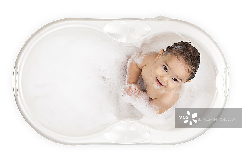 白色浴缸里的婴儿抬头看着镜头图片素材