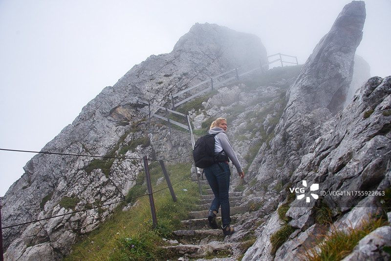 一名妇女在瑞士阿尔卑斯山徒步旅行的后视图，tomishorn山，埃芒塔尔阿尔卑斯山，瑞士图片素材