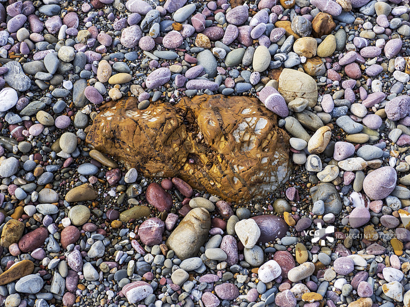 英国威尔士彭布罗克郡马洛斯金沙海滩上五颜六色的鹅卵石。图片素材