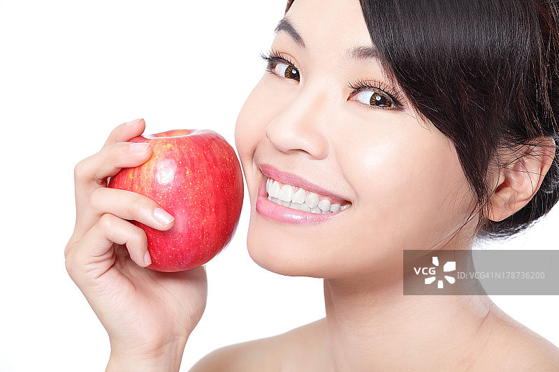 一个年轻女子拿着一个新鲜成熟的苹果图片素材