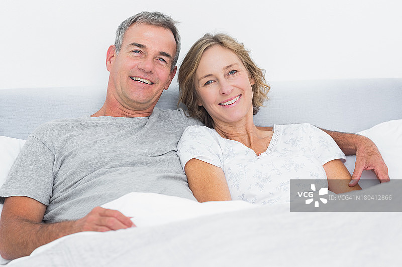 幸福的夫妇拥抱在床上看图片素材