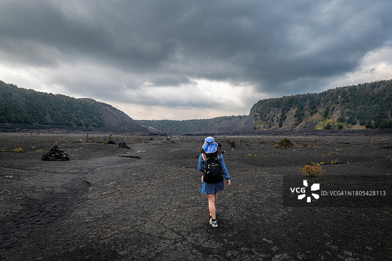 在夏威夷火山国家公园的基拉韦厄伊基小径上徒步旅行的成年女性图片素材