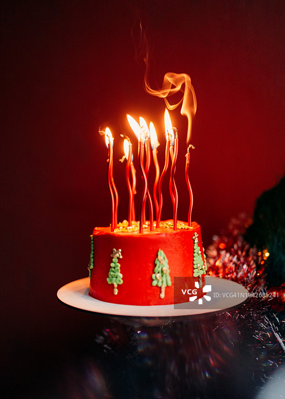 女人的手拿着红色的生日蛋糕和圣诞树图片素材