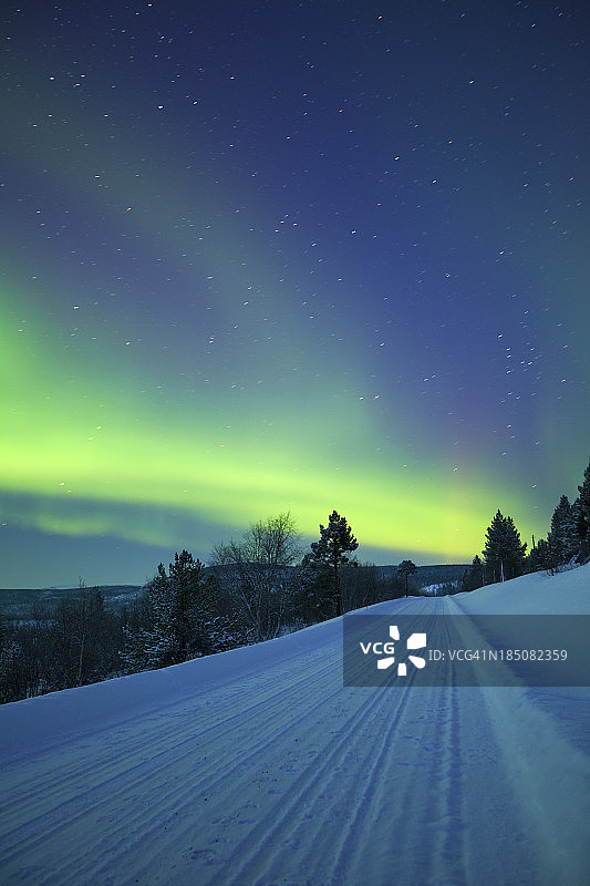 芬兰拉普兰冬季的风景，北极光在公路上图片素材