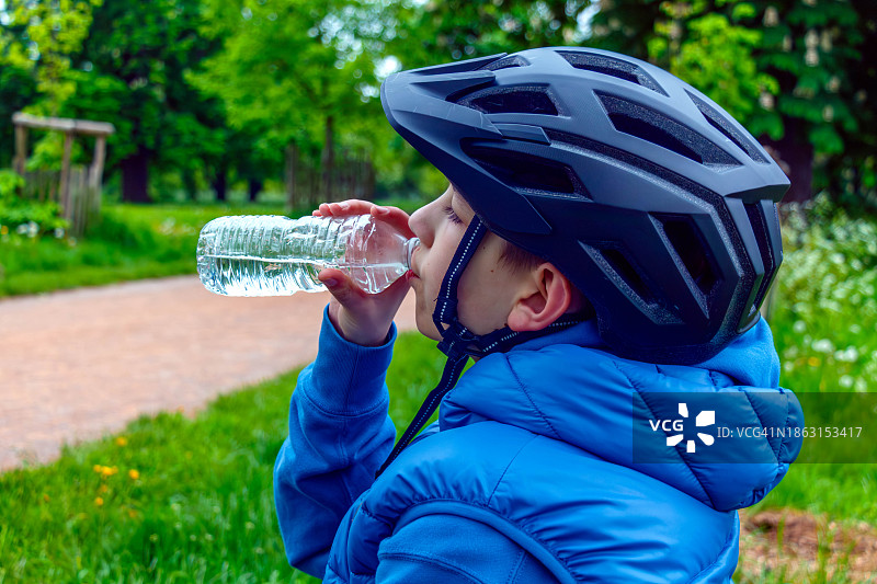 一个男孩骑自行车休息后喝水图片素材