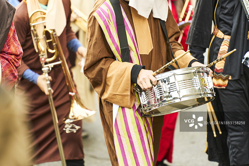 一群节日音乐家在城市街道上演奏鼓和其他乐器的正面视图图片素材
