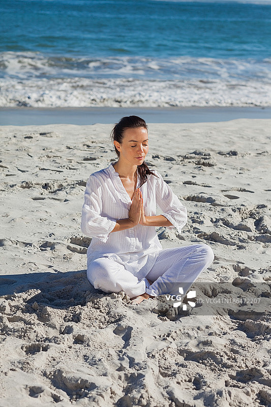 平静的女人在海边练习瑜伽图片素材