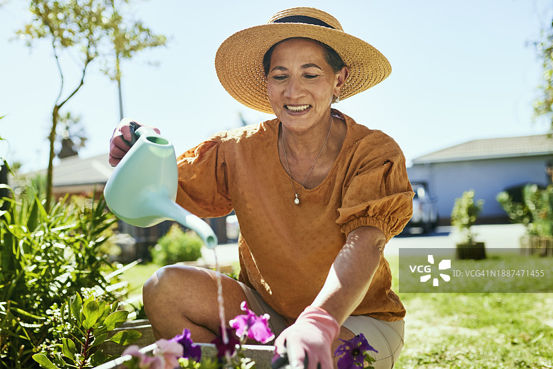 园艺是一种放松和享受户外活动的好方法。这位妇女正在照料她的花草。图片素材