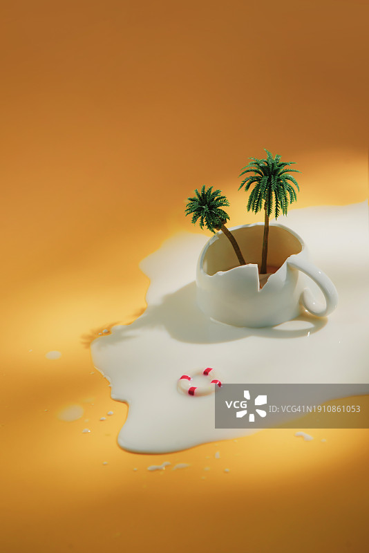 荒岛概念，有棕榈树的破杯子和洒出来的牛奶图片素材