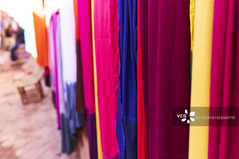 阿拉伯商店的墙上挂着一组各种颜色的手工织物的侧视图。图片素材