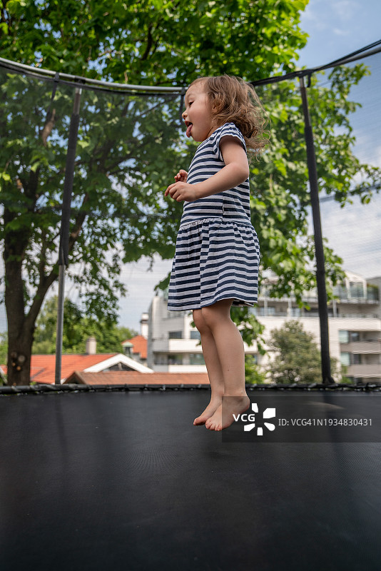 一个小女孩在玩蹦床图片素材