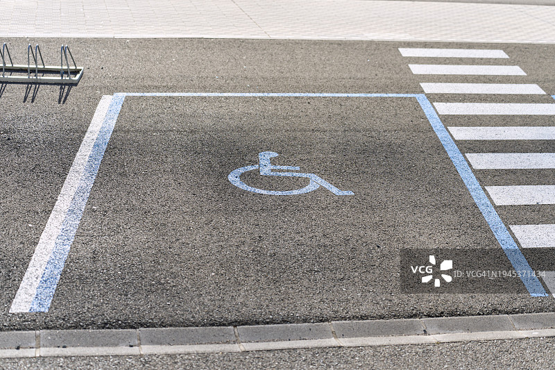 一个没有人的空停车场的轮椅残疾人标志的高角度前视图。图片素材