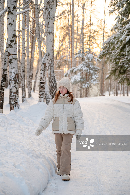 女子站在白雪覆盖的田野上的肖像图片素材
