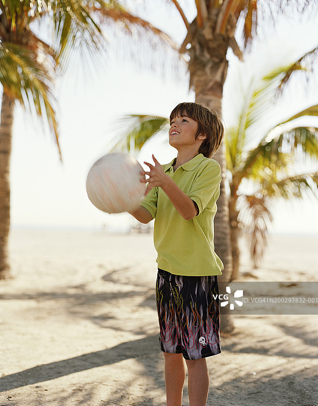 男孩(8-10)弹着球，微笑着图片素材