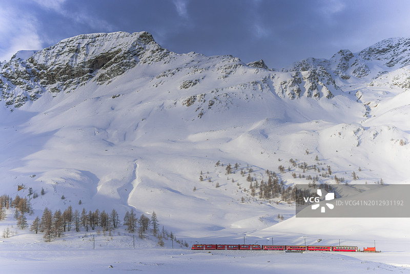 瑞士雪景中的红色贝尔尼纳特快列车图片素材