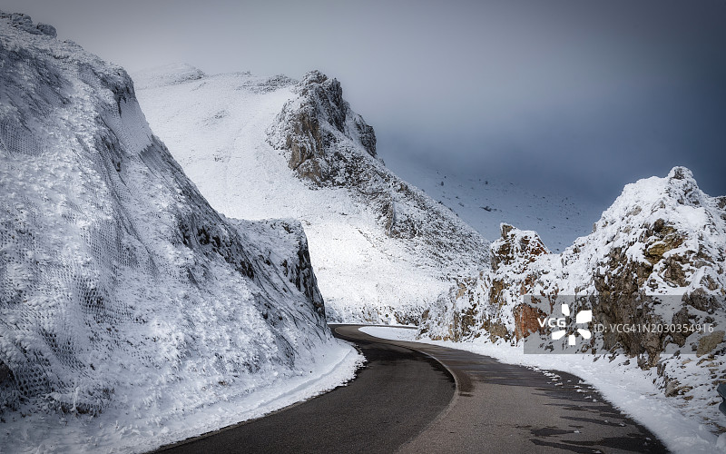 空荡的道路在白雪覆盖的山对着天空图片素材
