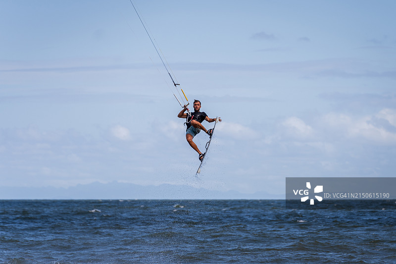 风筝冲浪者在海洋上空翱翔。图片素材