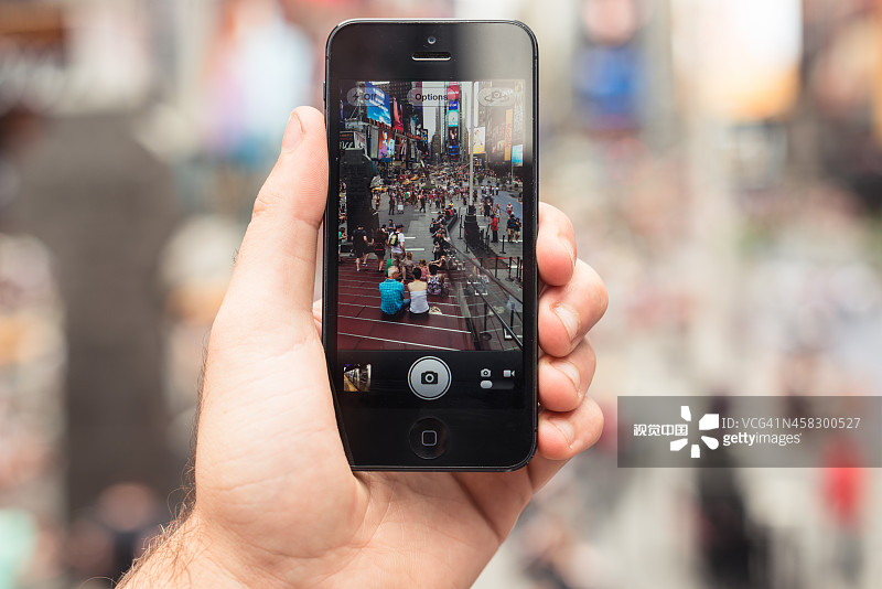 拿着苹果iPhone 5在时代广场图片素材