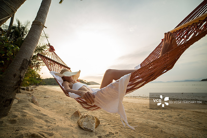 在热带度假的吊床上睡觉的女人图片素材
