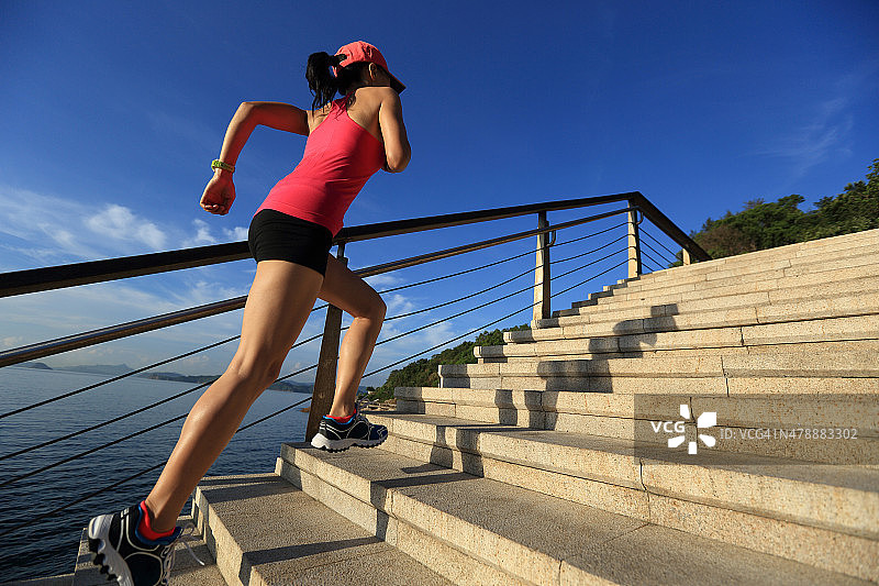 健康的生活方式运动女人跑上海边的石头楼梯图片素材