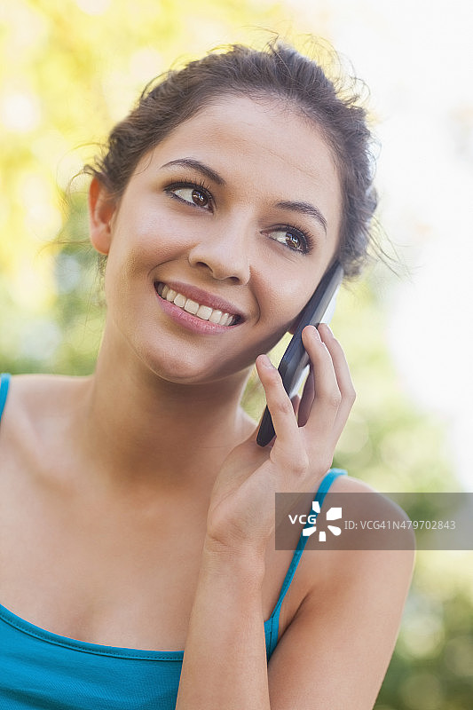 可爱的黑发女人用智能手机打电话图片素材