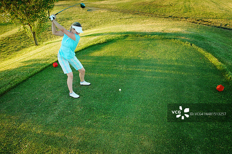年轻女子打高尔夫球图片素材