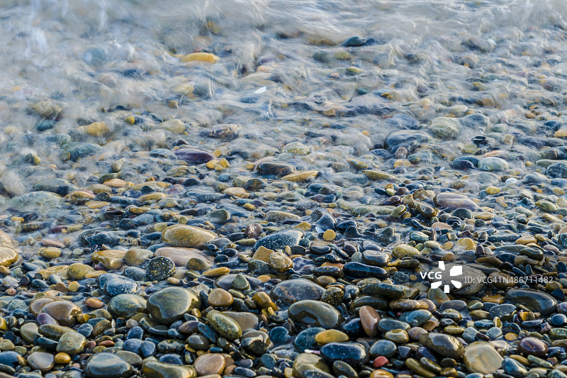 沙滩上五颜六色潮湿的鹅卵石图片素材