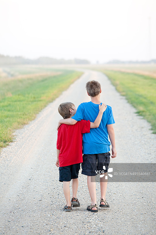 两个男孩走在乡间小路上图片素材