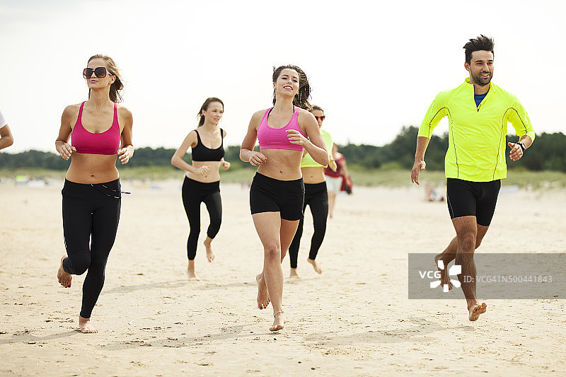 一群朋友在海滩上慢跑图片素材