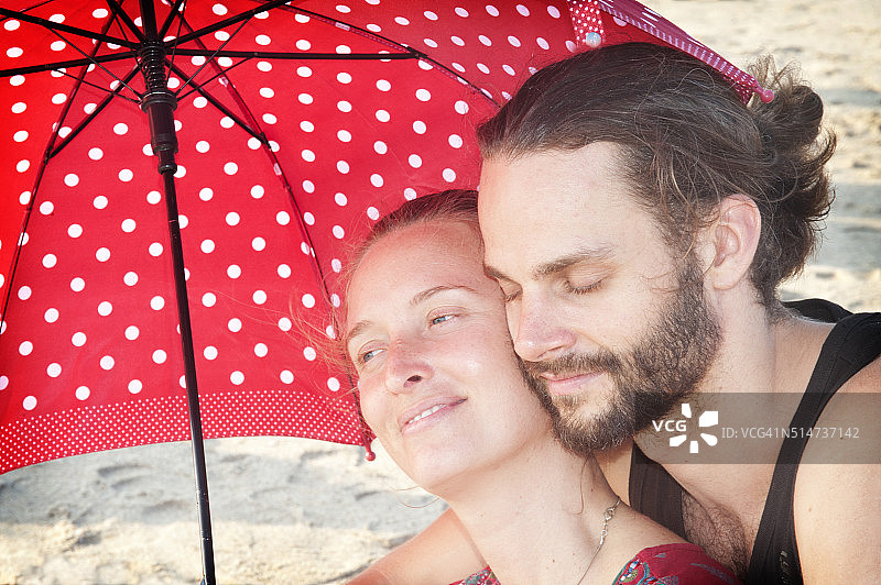 一对可爱的情侣在海滩上拥抱着彼此图片素材