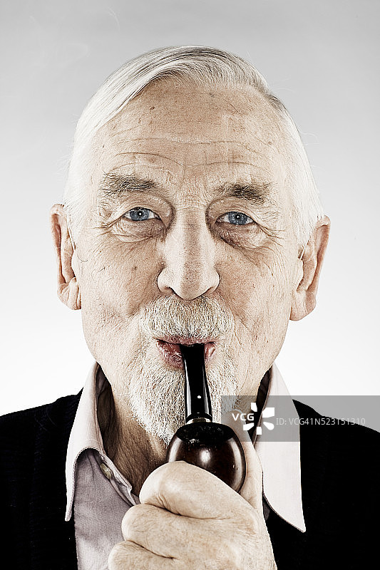 一个拿着管子的老人的肖像图片素材