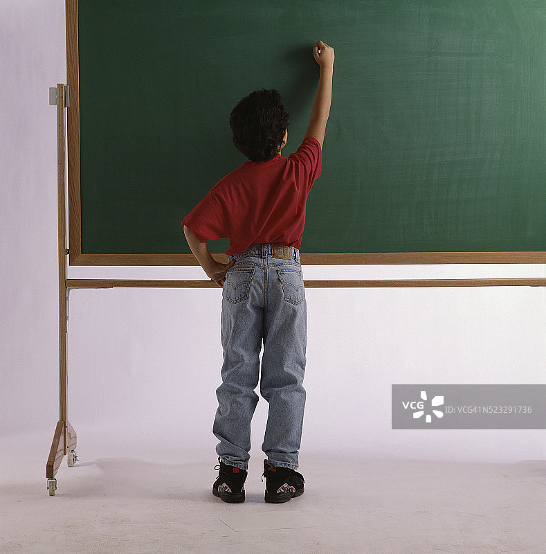 男孩在黑板上写字图片素材