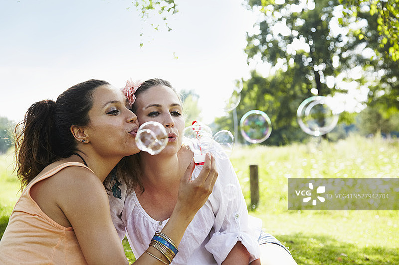 两个年轻女人在公园吹肥皂泡图片素材