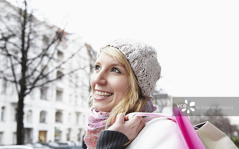 女人的肖像在羊毛帽子携带购物袋图片素材
