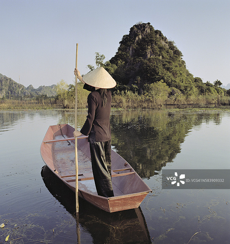 在香水宝塔附近，身着传统服饰的女子在河边引导平底船图片素材
