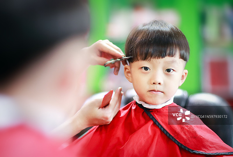 可爱的小男孩在剪头发图片素材