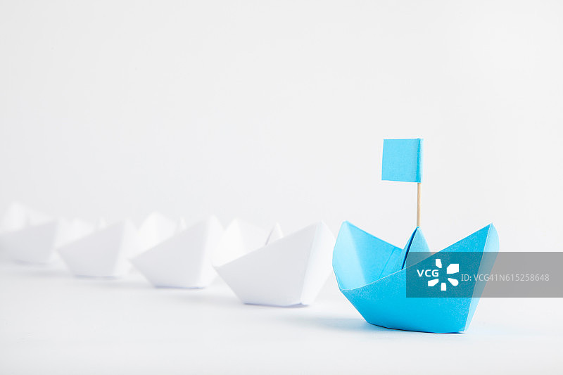 领导理念以蓝纸船领先于白船图片素材