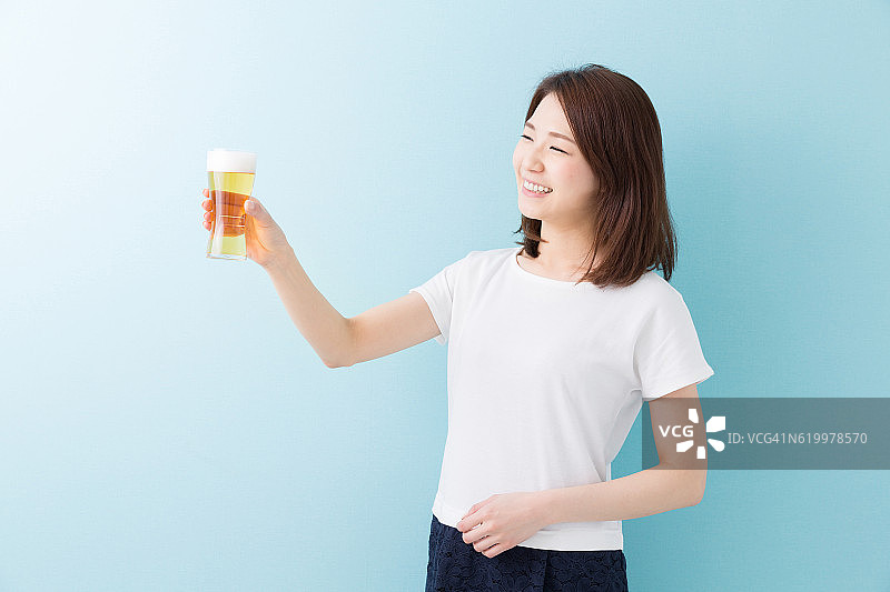 一个日本女人拿着一杯啤酒图片素材