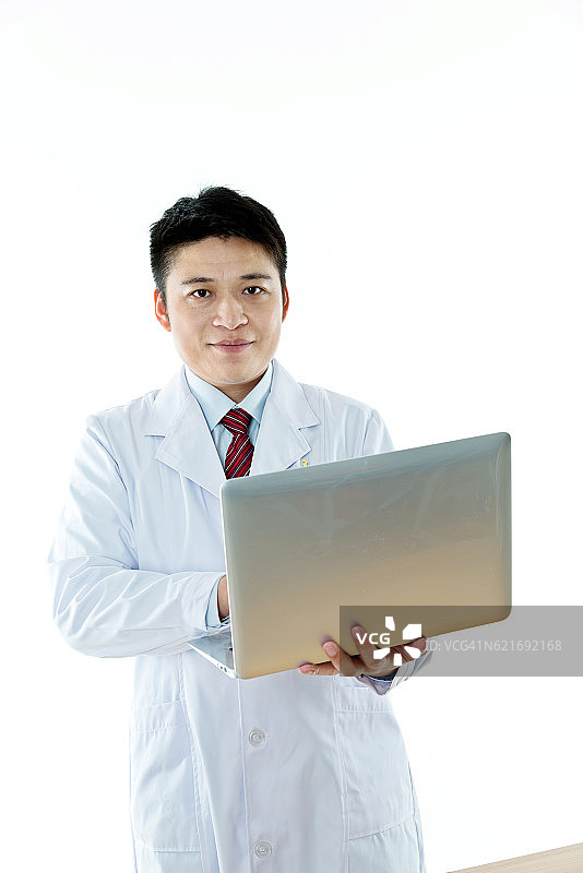 一个亚洲医生拿着笔记本电脑图片素材