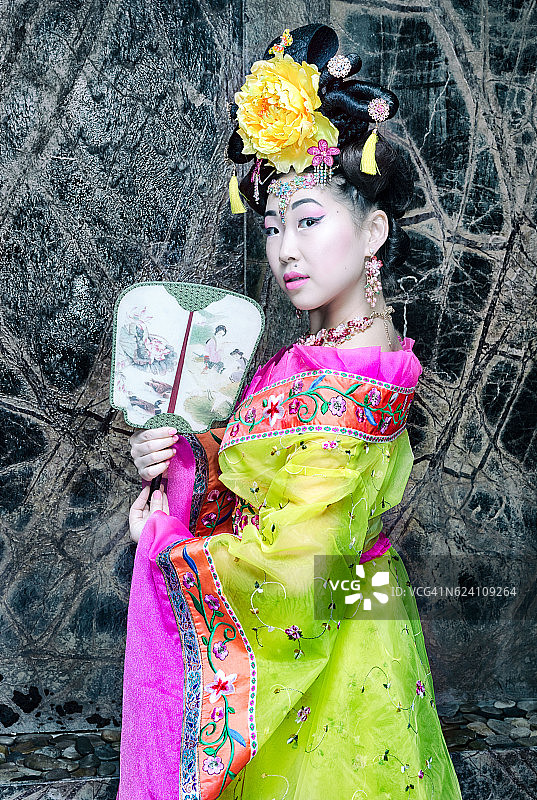 美丽的艺妓与乐趣在传统的中国黄色服装图片素材
