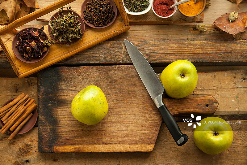 苹果放在木桌上准备做饭。图片素材