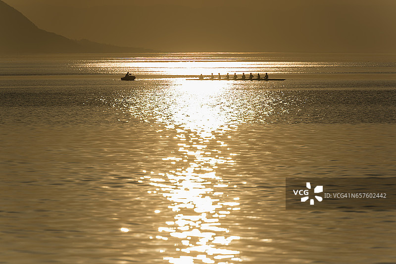 夕阳西下的日内瓦湖上划桨的队伍图片素材