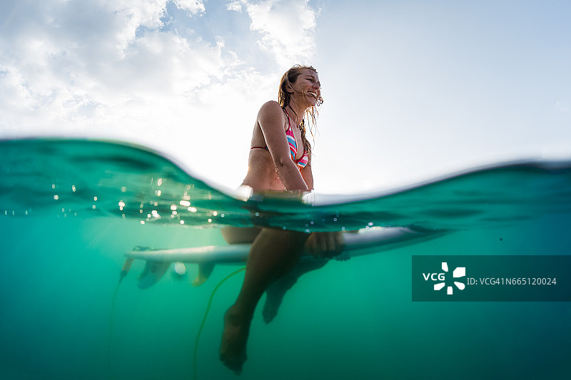水下的快乐女人坐在冲浪板上图片素材