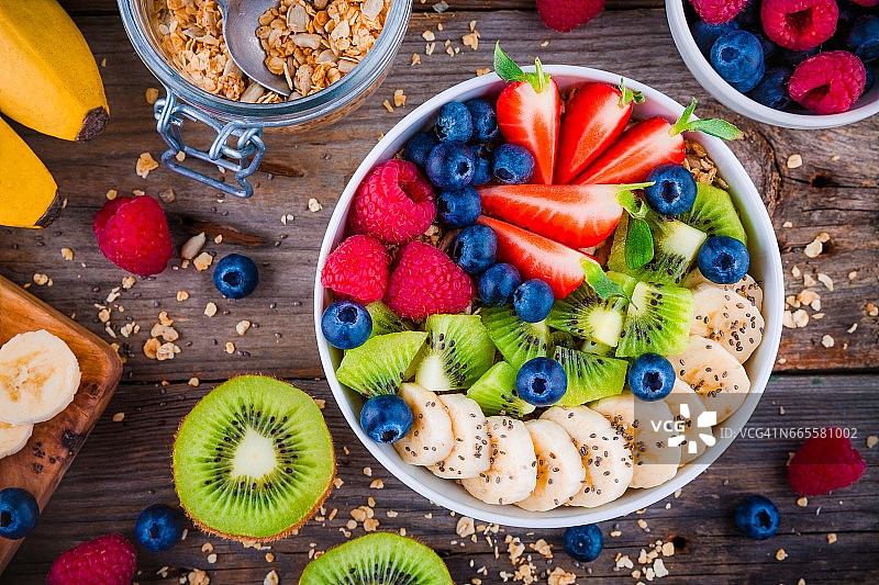 早餐碗:加香蕉、猕猴桃、覆盆子、草莓、蓝莓和奇异子的格兰诺拉麦片图片素材